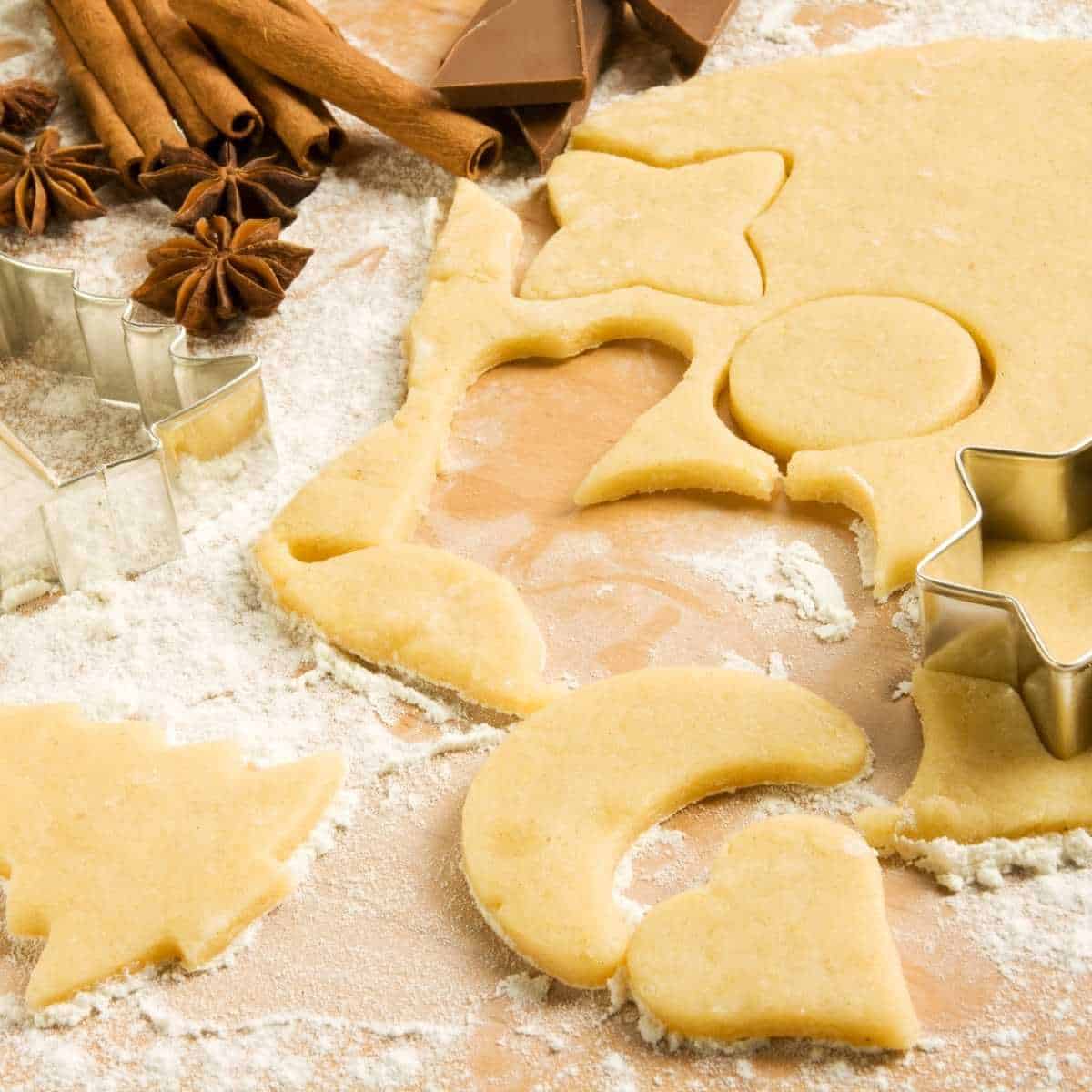Allergy friendly Christmas cookies being cut out on a floured board