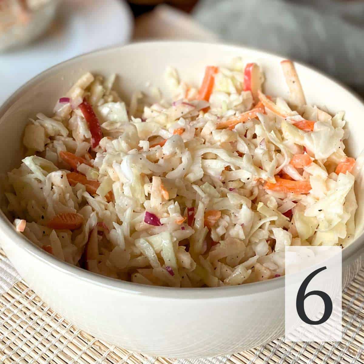 All of the cabbage apple salad ingredients mixed together in a bowl.