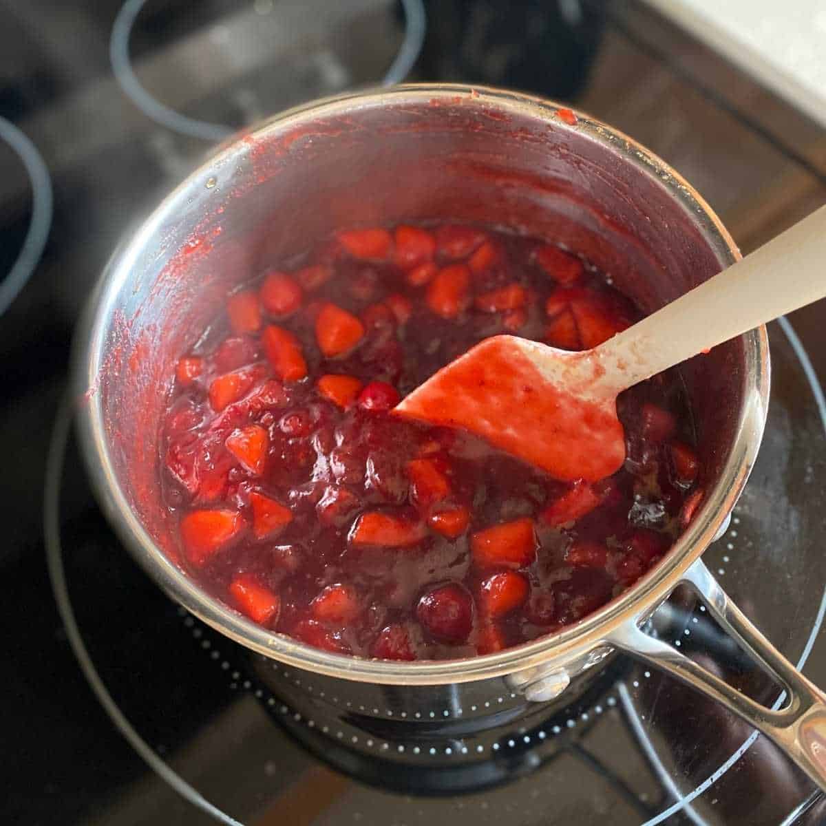 Cranberry apple sauce being stirred as it cooks.