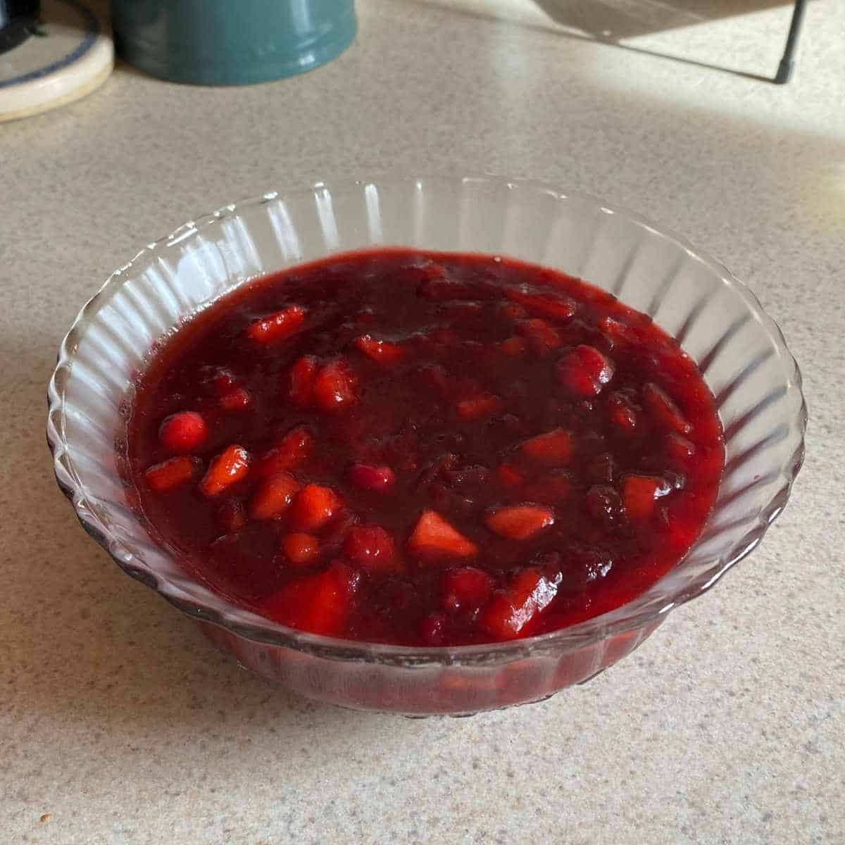 Cranberry apple sauce in a glass bowl.