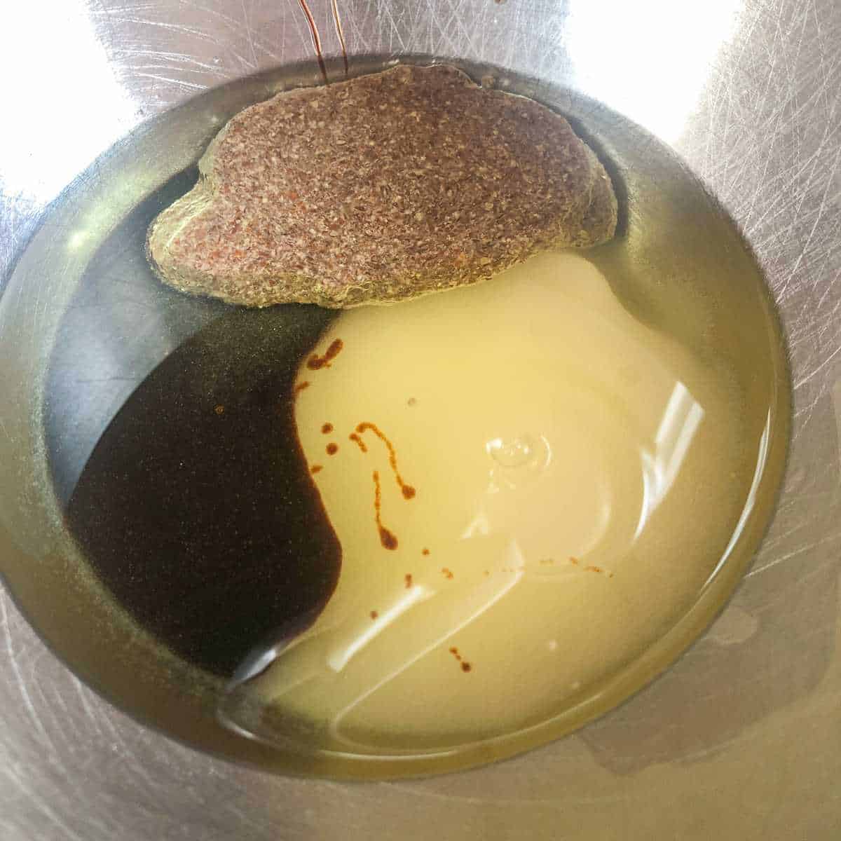 Ground flax and water mixture, molasses, oil, and sugar in a large mixing bowl.