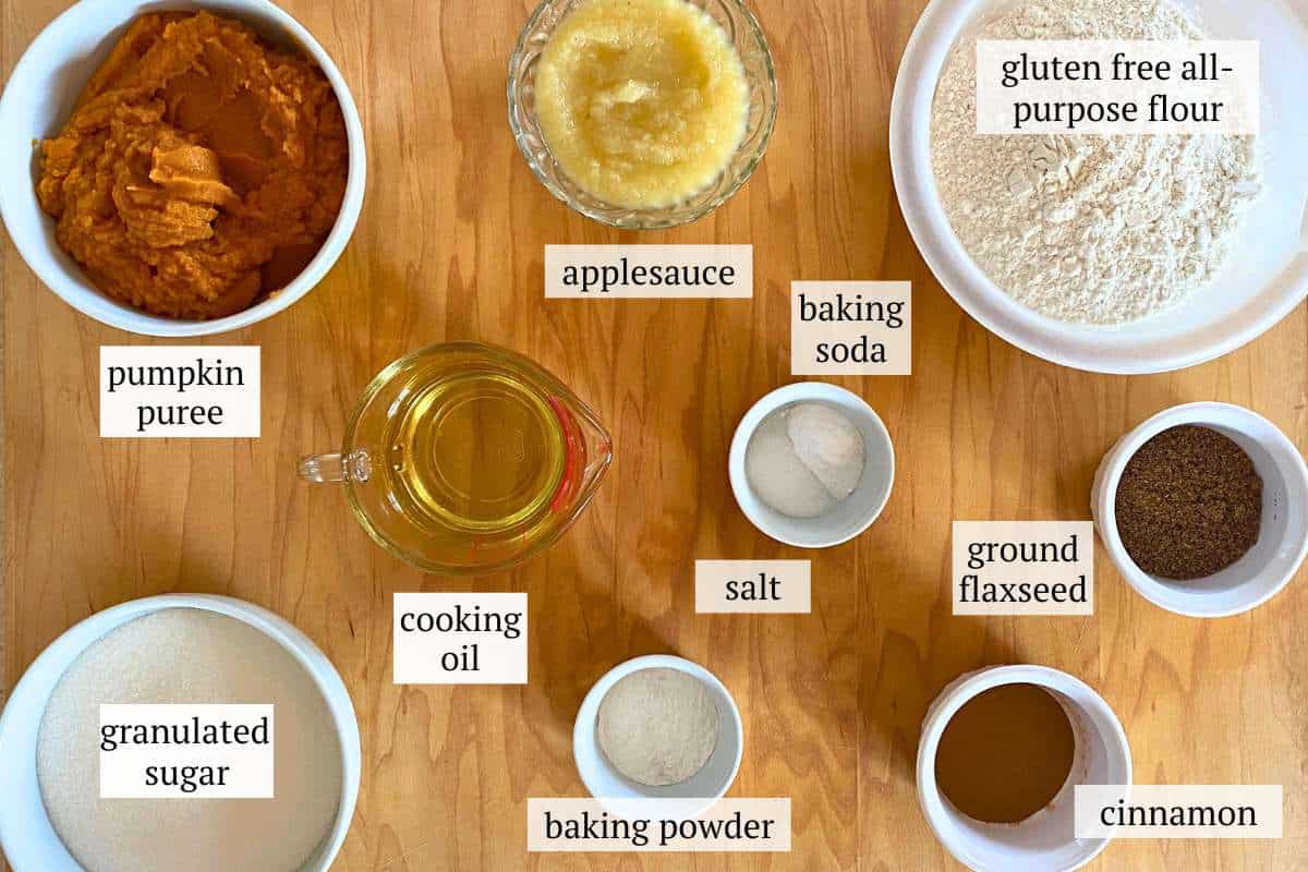 Bowls of ingredients needed for gluten free pumpkin bars including pumpkin puree, sugar, cooking oil, salt, baking powder, baking soda, ground flaxseed, cinnamon, applesauce, and gluten free flour.