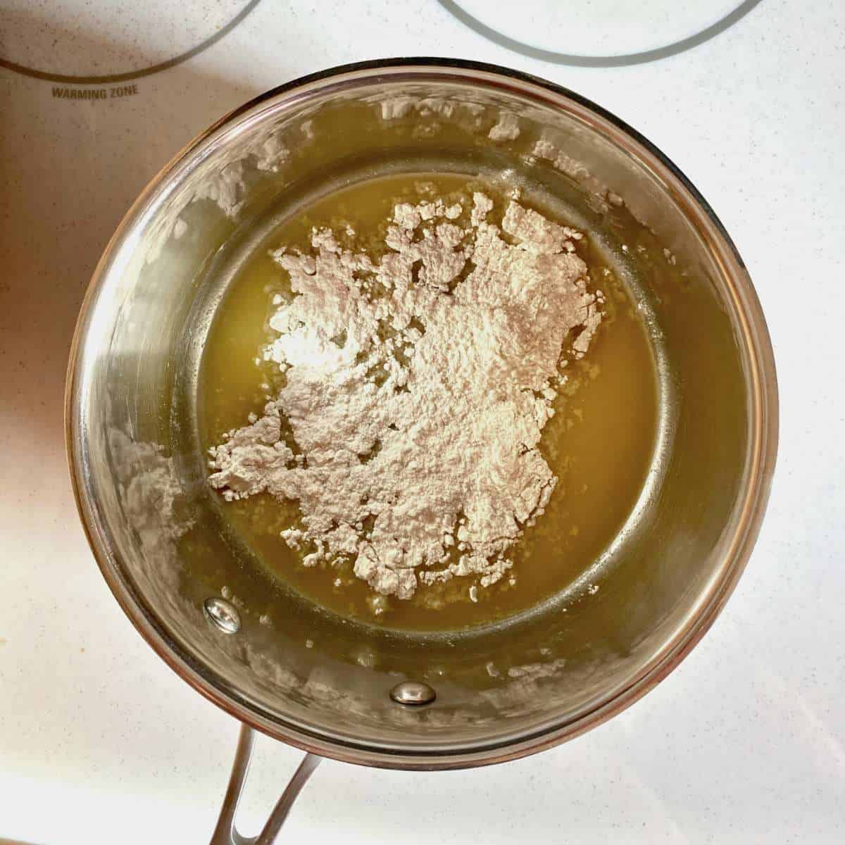 gluten free flour sprinkled over melted dairy free margarine in a saucepan