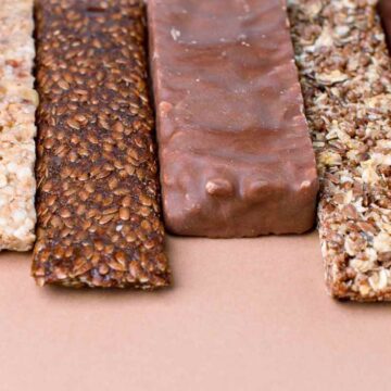 A variety of protein bars on a brown surface.